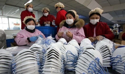 Các nhà máy sản xuất khẩu trang ở Trung Quốc hoạt động hết công suất trong đợt dịch virus Corona. Ảnh: EPA
