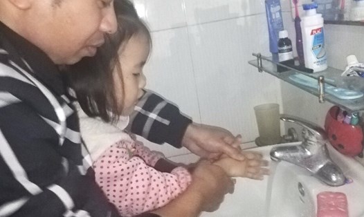 Anh Nguyễn Văn Thăng (CN thuê trọ tại toà nhà CT1A, Khu nhà Công nhân ở Kim Chung, Đông Anh, Hà Nội) hướng dẫn con rửa tay đúng cách để phòng virus Corona. Ảnh: H.A