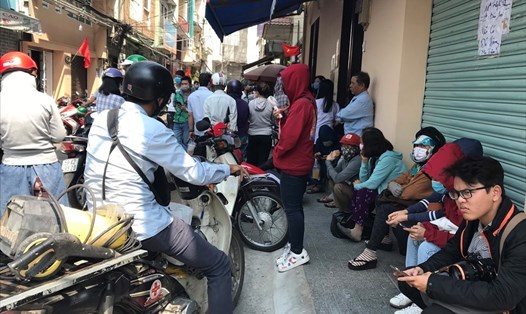 Nhiều người ngồi đợi đến giờ mua khẩu trang tại một cửa hàng trên đường Nguyễn Giản Thanh, quận 10, TPHCM. Ảnh: Anh Nhàn