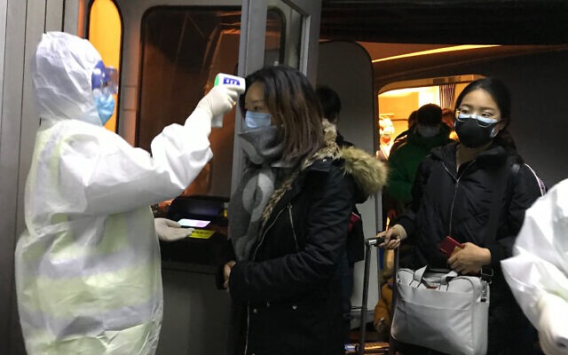 Đo thân nhiệt để sàng lọc hành khách tại sân bay Bắc Kinh. Ảnh: AP