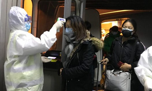 Đo thân nhiệt để sàng lọc hành khách tại sân bay Bắc Kinh. Ảnh: AP