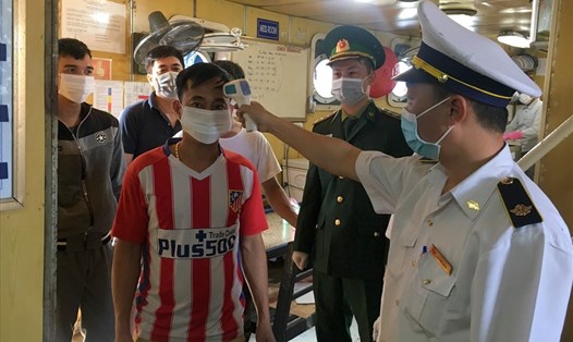 Cán bộ kiểm dịch và Đồn Biên phòng Cửa khẩu cảng Cửa Việt kiểm tra thân nhiệt thuyền viên trở về từ Trung Quốc. Ảnh: CT.