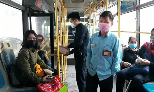 Nhân viên xe buýt thuộc Tổng Công ty Vận tải Hà Nội tặng khẩu trao cho hành khách. Ảnh: Hoa Lê