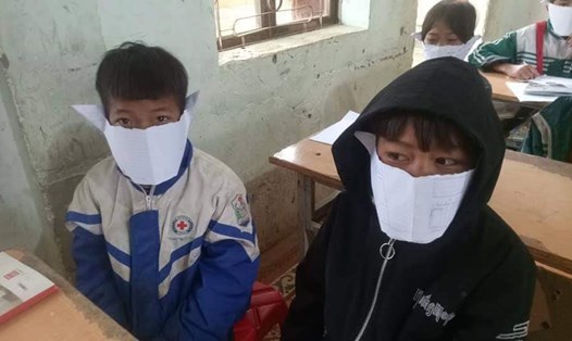 Các em học sinh tại một huyện miền núi Nghệ An lấy giấy làm thành khẩu trang để phòng dịch virus Corona. Ảnh: LO THAM