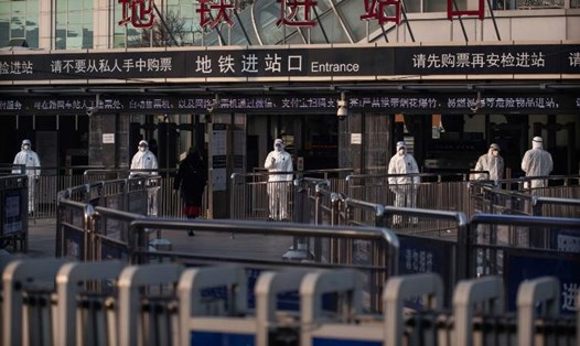 Nhân viên y tế của Trung Quốc kiểm tra thân nhiệt của hành khách tại một ga tàu điện ngầm ở Bắc Kinh, Trung Quốc. Ảnh: CNN