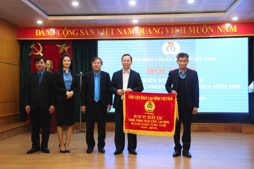 Đồng chí Trần Văn Thuật, Phó Chủ tịch Tổng LĐLĐVN (ngoài cùng bên phải) tặng Cờ thi đua của Tổng LĐLĐVN cho Công đoàn Ngân hàng Việt Nam. Ảnh: N.H
