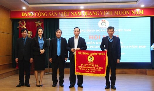 Đồng chí Trần Văn Thuật, Phó Chủ tịch Tổng LĐLĐVN (ngoài cùng bên phải) tặng Cờ thi đua của Tổng LĐLĐVN cho Công đoàn Ngân hàng Việt Nam. Ảnh: N.H