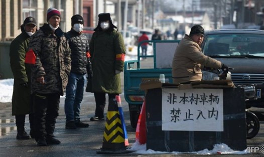 Người dân đứng gác ở lối vào 1 ngôi làng ở phía bắc Bắc Kinh nhằm ngăn chặn sự lây lan của virus. Ảnh: AFP