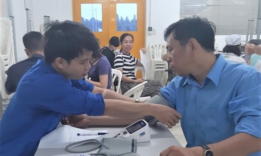 Ông Lưu Kim Hồng (bên phải) chuẩn bị hiến máu tại Công ty. Ảnh: NVCC