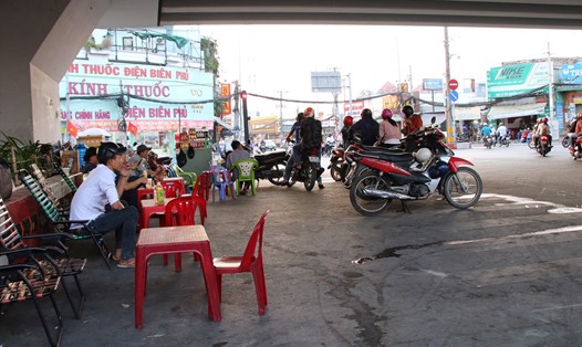 Nhiều hộ dân ngang nhiên mở quán cà phê kinh doanh tại gầm cầu vượt (đoạn giao cắt quốc lộ 1A với tỉnh lộ 10, quận Bình Tân). Ảnh TK.