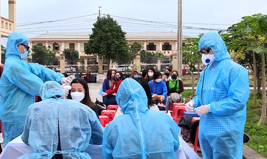 Các nhân viên y tế tiến hành khám sức khỏe sàng lọc đối với những công dân Việt Nam trở về từ Hàn Quốc và đang được cách ly tập trung tại Trung đoàn 855 (thuộc Bộ CHQS tỉnh Ninh Bình). Ảnh: NT