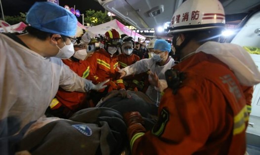 Hai mẹ con cậu bé 10 tuổi được cứu sống sau 52 giờ mắc kẹt trong đống đổ nát của vụ sập toà nhà ở Phúc Kiến. Ảnh: China Daily