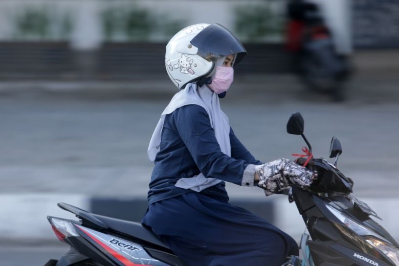 Một phụ nữ mang khẩu trang lưu thông trên đường phố tại Indonesia. Ảnh: Straits Times.