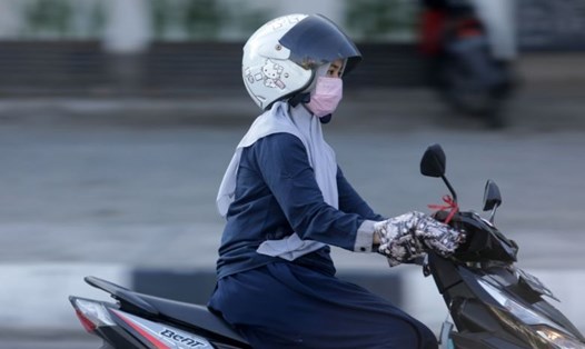 Một phụ nữ mang khẩu trang lưu thông trên đường phố tại Indonesia. Ảnh: Straits Times.