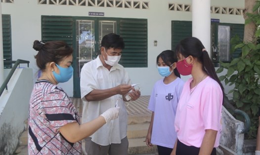 Các em học sinh Trường THPT dân tộc nội trú tỉnh Khánh Hoà được kiểm tra thân nhiệt trước khi nhập trường. Ảnh:P.Linh