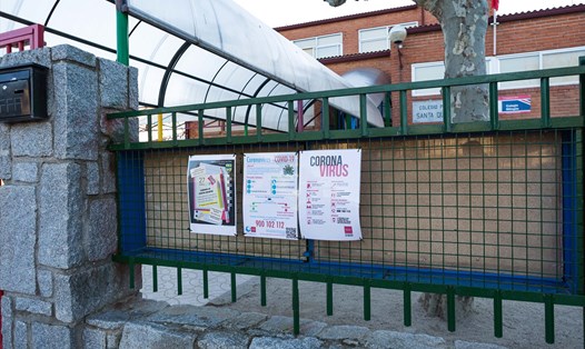 Tờ thông tin về COVID-19 được dán trên một cổng trường học ở Tây Ban Nha khi nước này đóng cửa các trường học ngăn ngừa lây lan virus. Ảnh: CNN
