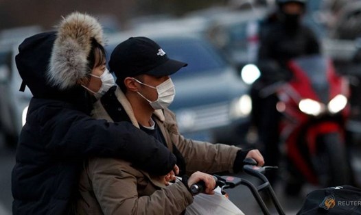 Người dân đeo khẩu trang di chuyển trên đường phố Bắc Kinh, Trung Quốc. Ảnh: CNA.