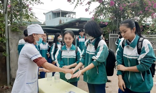 Học sinh khối Trung học Phổ thông tại tỉnh Quảng Trị đến trường được nhân viên y tế hướng dẫn rửa tay sát khuẩn phòng dịch COVID-19. Ảnh: TT.