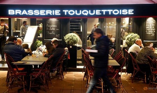 Mọi người đang thưởng thức ẩm thực tại một quán cà phê ở Pháp, dù số ca mắc COVID-19 ở quốc gia này tăng từng ngày. Ảnh: Reuters