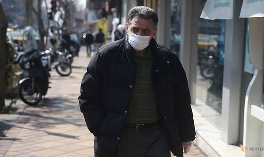 Một người đàn ông Iran đeo khẩu trang trong đại dịch COVID-19 - bệnh dịch đã làm hơn 100 người tử vong ở Iran chỉ trong vòng 24 giờ. Ảnh: Reuters