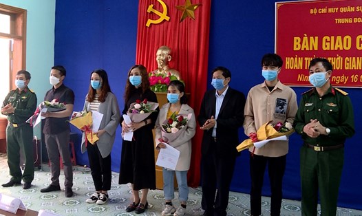 Đại diện lãnh đạo sở Y tế tỉnh Ninh Bình và Trung đoàn 855 tặng hoa chúc mừng những công dân đã hoàn thành xong thời gian cách ly tập trung. Ảnh: NT