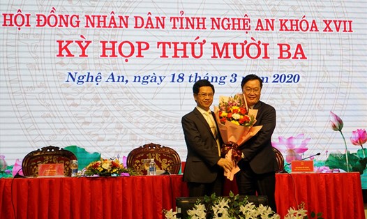 Chủ tịch HĐND tỉnh Nghệ An (trái) tặng hoa chúc mừng ông Nguyễn Đức Trung- tân Chủ tịch UBND tỉnh Nghệ An. Ảnh: QĐ
