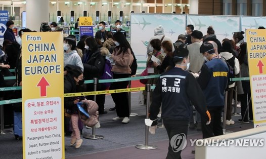 Hành khách trên chuyến bay tới từ Paris đang xếp hàng tại khu vực sàng lọc kiểm tra đặc biệt ở sân bay quốc tế Incheon, phía tây Seoul ngày 16.3. Ảnh: Yonhap