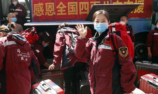 Các nhân viên y tế vẫy chào tạm biệt trước khi rời Vũ Hán, tỉnh Hồ Bắc, Trung Quốc. Ảnh: Xinhua.