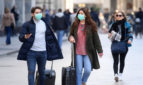 Người đi bộ đeo khẩu trang ở Milan, Italia. Ảnh: Tân Hoa Xã.