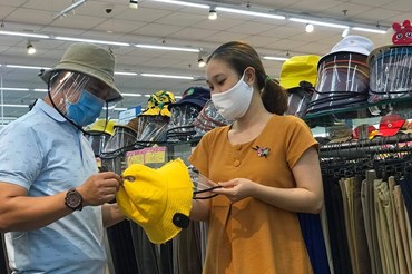 khách chọn mua nón chống dịch tại siêu thị Co.opmart Tân An.