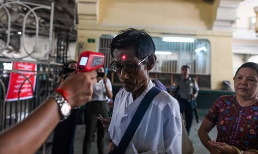 Kiểm tra thân nhiệt của hành khách tại nhà ga đường sắt trung tâm ở Yangon, Myanmar, ngày 19.3. Ảnh: AFP