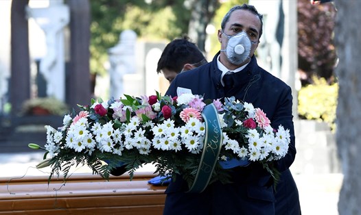 Nhân viên nghĩa trang ở Italia, nước có số tử vong do COVID-19 cao nhất thế giới. Ảnh: Reuters