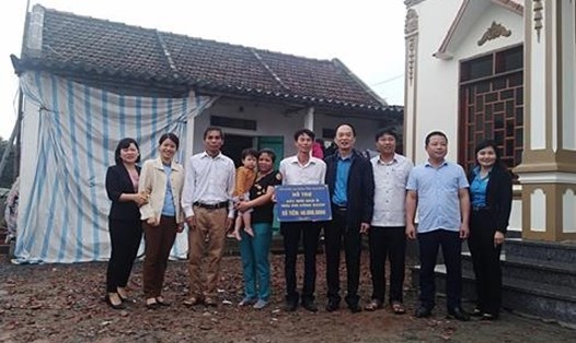 Đoàn đại biểu cùng anh Nguyễn Văn Dũng bên ngôi nhà mới xây.