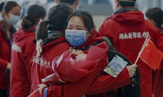 Hai nhân viên y tế ôm chào tạm biệt nhau tại một sân ga của tỉnh Hồ Bắc sau khi hoàn thành sứ mệnh điều trị cho bệnh nhân mắc COVID-19. Ảnh: Xinhua