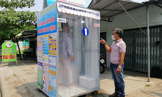 Anh Quang hướng dẫn người dân sử dụng trong Phòng khử khuẩn toàn thân di động.