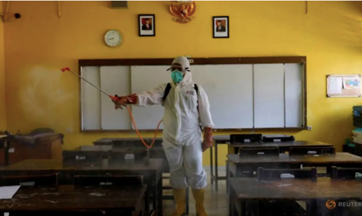 Một nhân viên y tế đang làm công tác khử trùng tại một lớp học ở Jakarta, Indonesia, ngày 16.3. Ảnh: Reuters