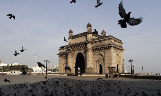 Chim bồ câu bay trước cổng đài tưởng niệm không một bóng người vì lệnh phong tỏa toàn quốc do COVID-19 ở Mumbai, Ấn Độ. Ảnh:AP