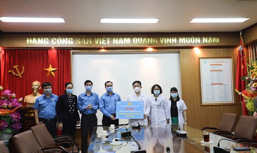 Chủ tịch Tổng LĐLĐVN Nguyễn Đình Khang (thứ 4 từ trái sang) trao hỗ trợ tới Bệnh viện Bạch Mai chiều 25.3. Ảnh: Việt Lâm