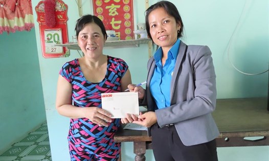 Đại diện Quỹ XHTT Tấm lòng Vàng trao 2.700.000 đồng của bạn đọc Báo Lao Động hỗ trợ gia đình chị Nguyễn Thị Hằng. Ảnh: PV