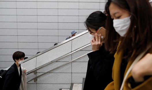 Hành khách đeo khẩu trang ngừa dịch COVID-19 tại một ga tàu ở Tokyo, Nhật Bản. Ảnh: Reuters