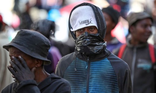 Một người đàn ông che mặt bằng túi nilon tại Nam Phi hôm 27.3. Ảnh: Reuters.