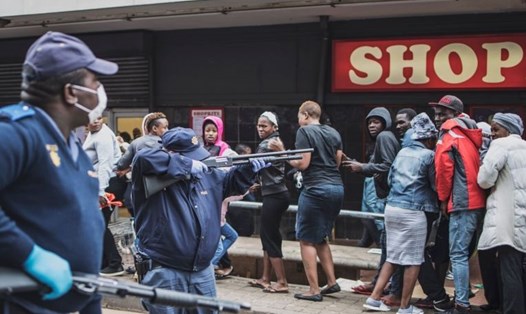 Cảnh sát Nam Phi phải dùng đến súng bắn đạn cao su để buộc người dân phải chấp hành quy tắc khoảng cách an toàn, tại Yeoville, Johannesburg ngày 28.3. Ảnh: AFP