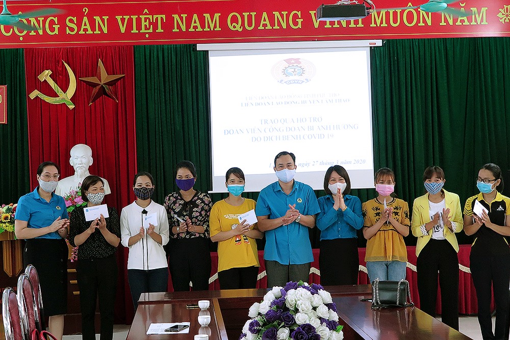Ông Phạm Sơn - Phó Chủ tịch Thường trực LĐLĐ tỉnh; lãnh đạo Ban Chính sách LĐLĐ tỉnh; LĐLĐ huyện Lâm Thao trao quà cho các đoàn viên.
