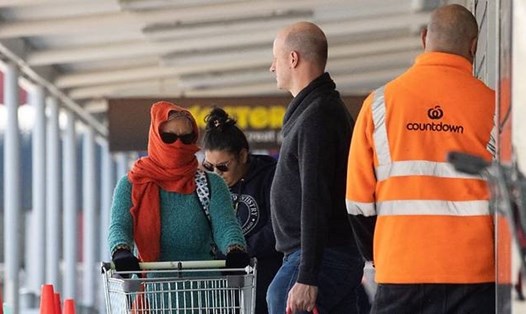 Một người phụ nữ đeo khẩu trang đợi vào siêu thị mua nhu yếu phẩm trong đại dịch COVID-19 ở thủ đô Wellington. Ảnh: AFP