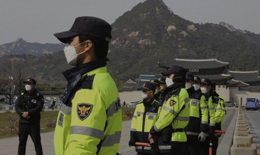 Cảnh sát đeo khẩu trang ngăn ngừa dịch COVID-19 trước Đại sứ quán Mỹ tại Seoul, Hàn Quốc. Ảnh: AP
