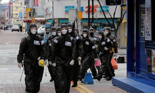 Binh sĩ Hàn Quốc làm nhiệm vụ khử trùng các toà nhà nhằm ngăn chặn sự lây lan của COVID-19. Ảnh: Reuters