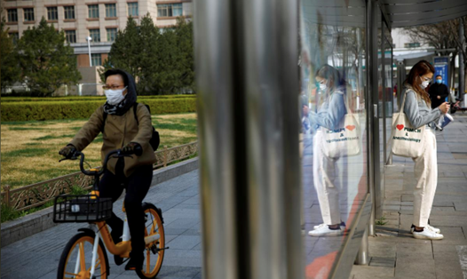 Người dân trên đường phố thủ đô Bắc Kinh, Trung Quốc, ngày 30.3. Ảnh: Reuters