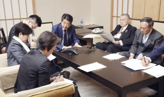 Thủ tướng Abe Shinzo cùng các quan chức phụ trách Olympic Tokyo dự cuộc họp trực tuyến với Chủ tịch IOC Thomas Bach hôm 24.3. Ảnh: Reuters