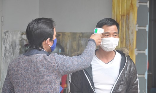 Nhân viên trạm y tế xã Sơn Lôi (huyện Bình Xuyên, tỉnh Vĩnh Phúc) đo nhiệt độ cho người bị cách ly tại nhà. Ảnh: Tất Thảo