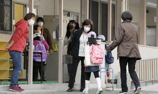 Trẻ em đến một trường học ở Fukuoka vào sáng thứ Hai. Trường học đóng cửa những vẫn có các lớp trông trẻ có bố mẹ đi làm. Ảnh: Kyodo